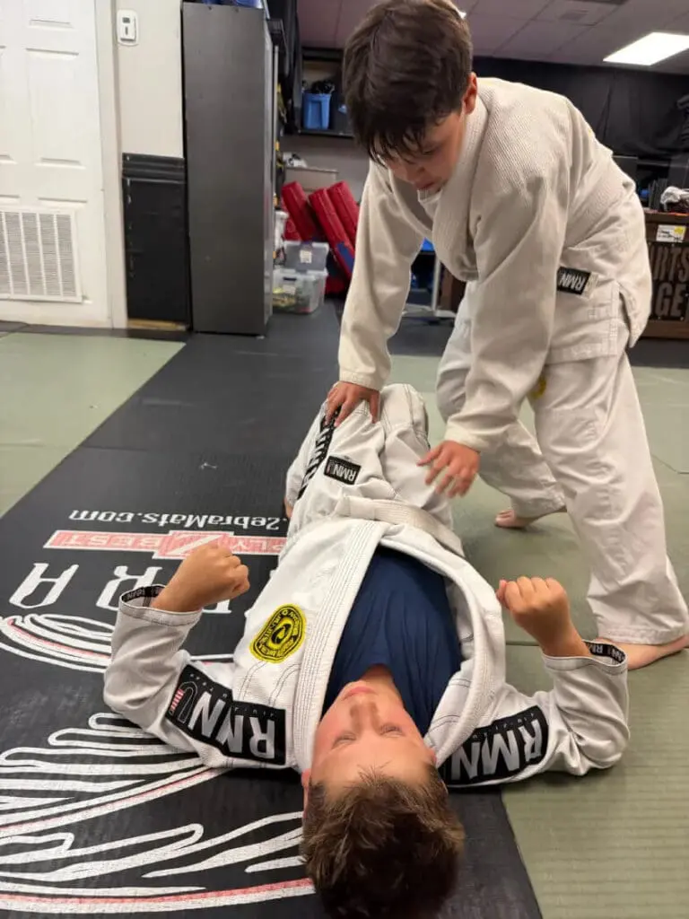 Student practicing guard control during class for brazilian jiu jitsu basics